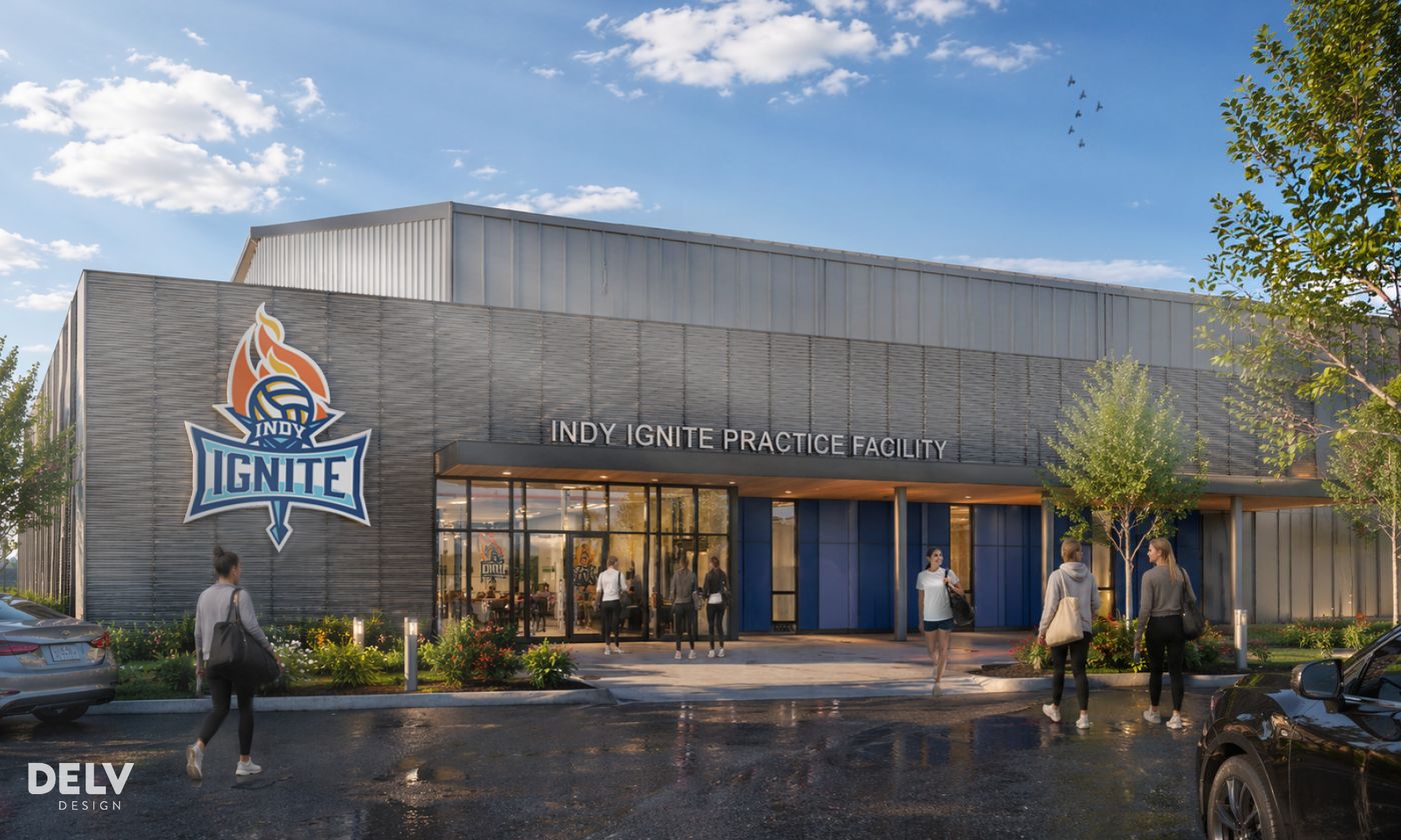 Rendering of the Indy Ignite practice facility exterior in Fishers, with the team logo on the gray facade and visitors walking toward the entrance