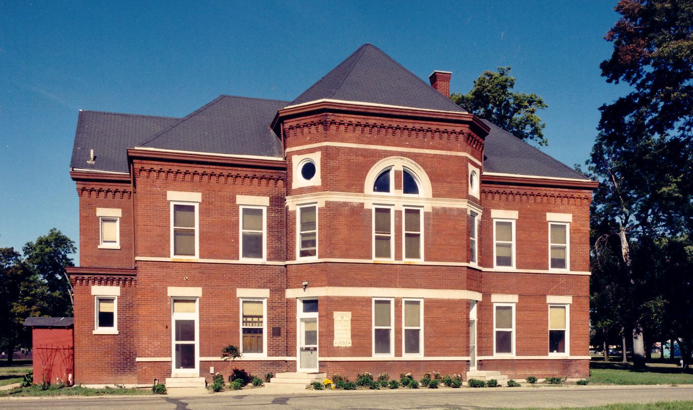 The red brick Old Pathology Building, home of the Indiana Medical History Museum, with its bay front and slate roof under a clear blue sky in Indianapolis.