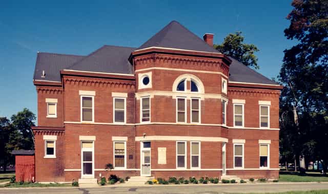The red brick Old Pathology Building, home of the Indiana Medical History Museum, with its bay front and slate roof under a clear blue sky in Indianapolis.