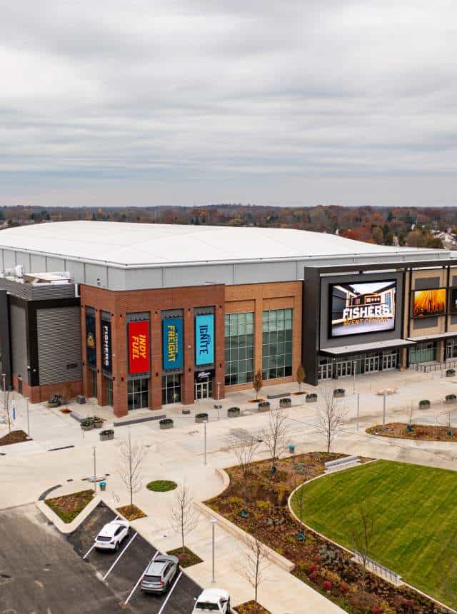 Aerial view of the Fishers Event Center with Indy Fuel, Freight and Ignite banners on its brick facade and a large video board by the entrance