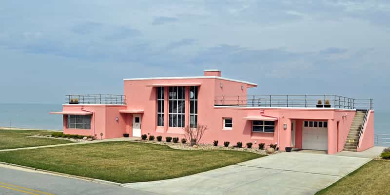 The pink Florida Tropical House, one of the 1933 Century of Progress homes, standing on a lawn above the Lake Michigan shoreline in Beverly Shores, Indiana