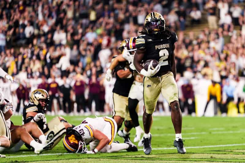 Purdue running back Fame Ijeboi, No. 2, holds the football after a touchdown run as a Minnesota defender lies on the turf at Ross-Ade Stadium