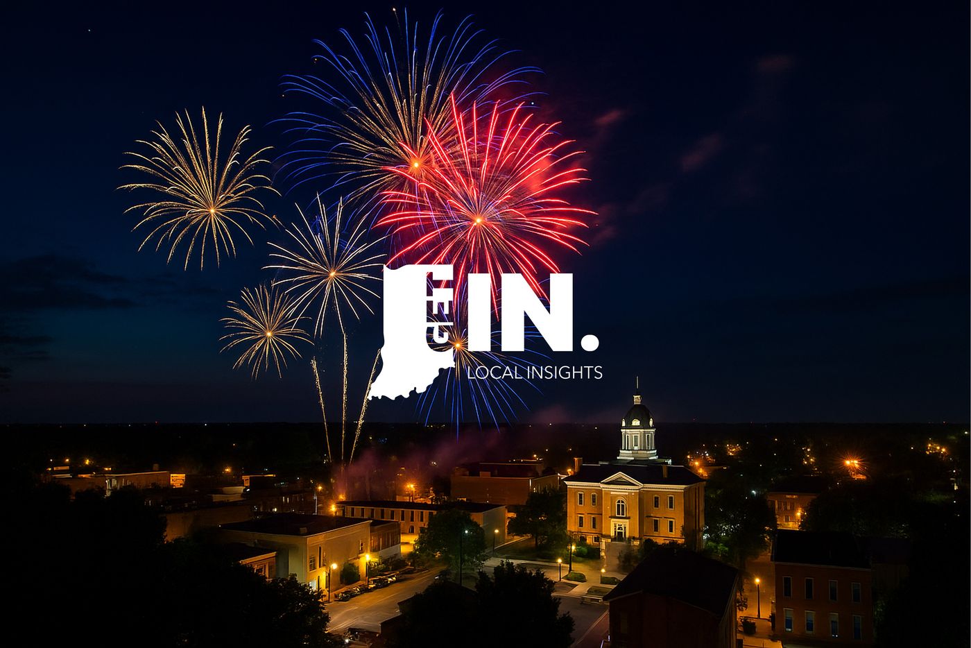Colorful Fourth of July fireworks over a historic county courthouse and a lit downtown at night