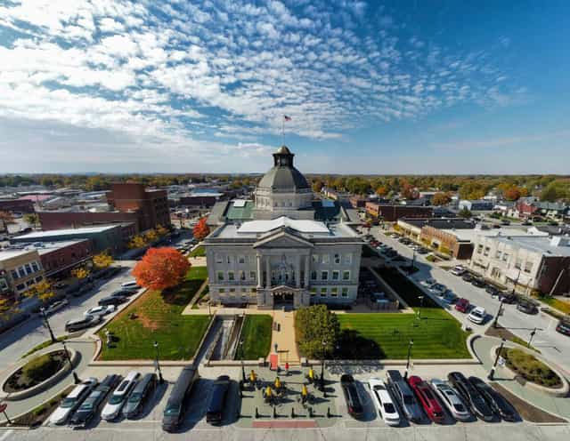 Aerial view of the Boone County courthouse and downtown square in Lebanon, Indiana, with fall foliage and parked cars lining the street