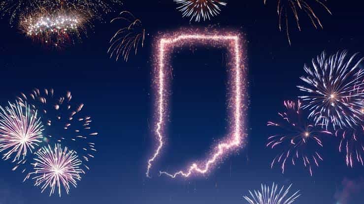 Fireworks forming the shape of the state of Indiana against a dark night sky, celebrating the Fourth of July.