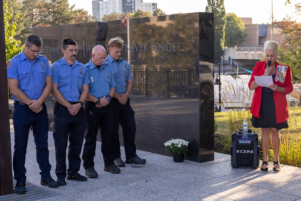 Indianapolis firefighters bow their heads at the black granite Never Forget wall on the Downtown Canal during a 9/11 ceremony.