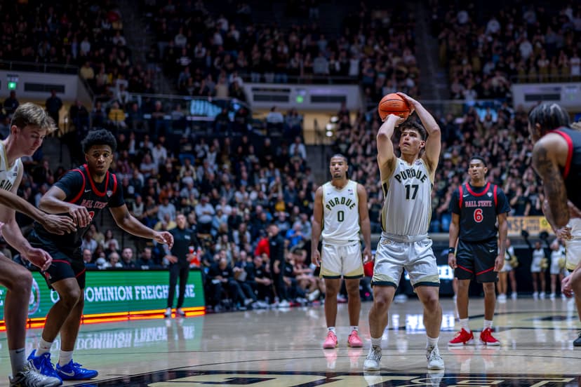 Purdue player wearing No. 17 shoots a free throw against Ball State as teammates and Ball State players line the lane in front of a packed crowd