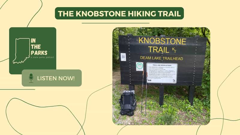 Knobstone Trail sign at the Deam Lake Trailhead with a hiking backpack and trekking poles leaning against it