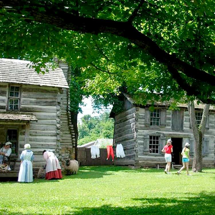 Costumed interpreters among the log cabins at Lincoln Pioneer Village