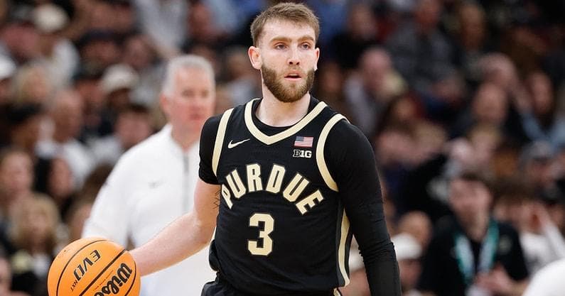 Braden Smith in a black Purdue number 3 jersey dribbling the ball up the court during a game