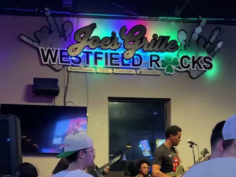 Joe's Grille Westfield Rocks sign above a live band on stage in Westfield