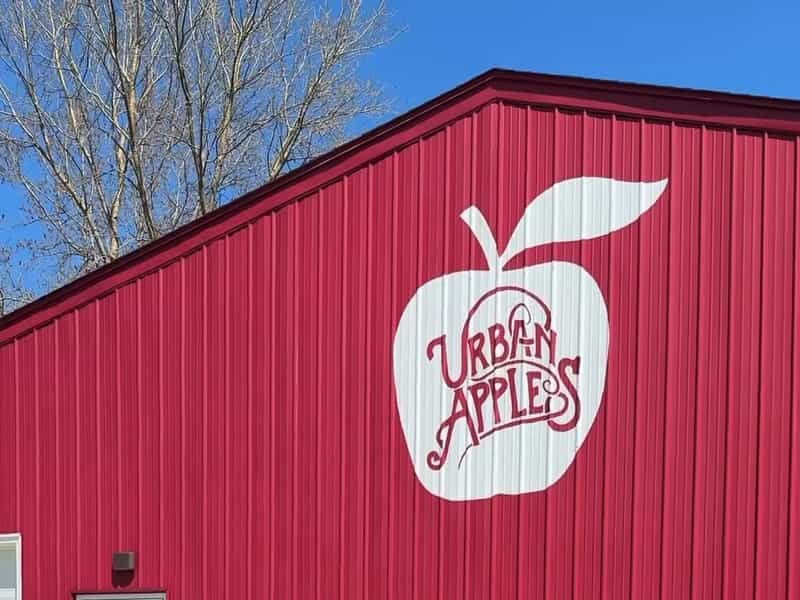 Painted apple logo on the red barn wall of Urban Apples Cidery & Restaurant in Westfield
