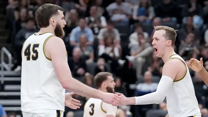 Purdue's Oscar Cluff, number 45, and Fletcher Loyer celebrating together on the court in white jerseys