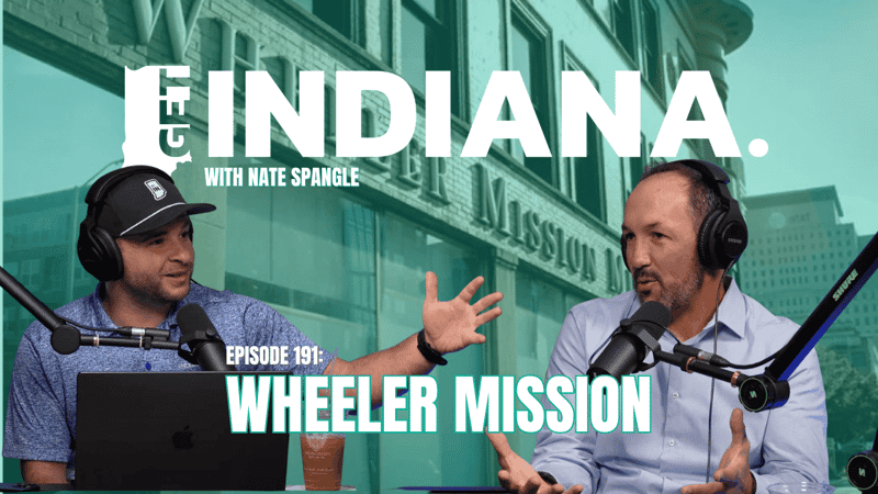 Two men discuss life-changing experiences in front of the historic Wheeler Mission building in Indiana.