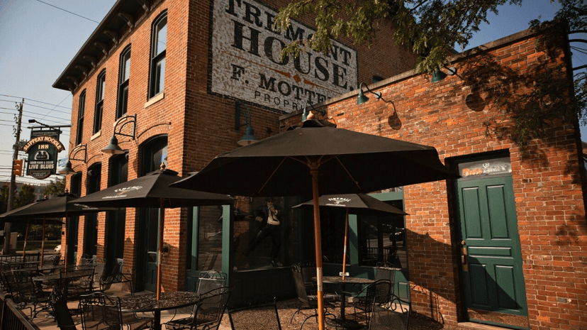 Brick exterior and patio of the Slippery Noodle Inn with a Tremont House sign