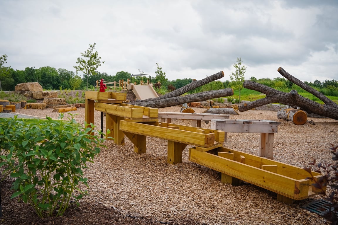 Wooden water play channels and log climbing structures at the nature playground in Carpenter Nature Preserve in Zionsville