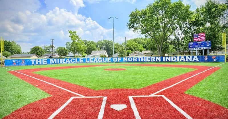 The rubberized red-and-green Pfeil Miracle Field at Normain Park in Mishawaka, with a Miracle League of Northern Indiana outfield banner and scoreboard.
