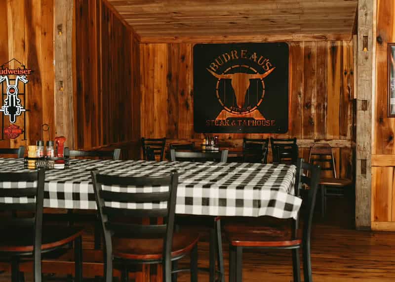 Budreau's Steak & Taphouse dining room with its longhorn sign on the wood wall