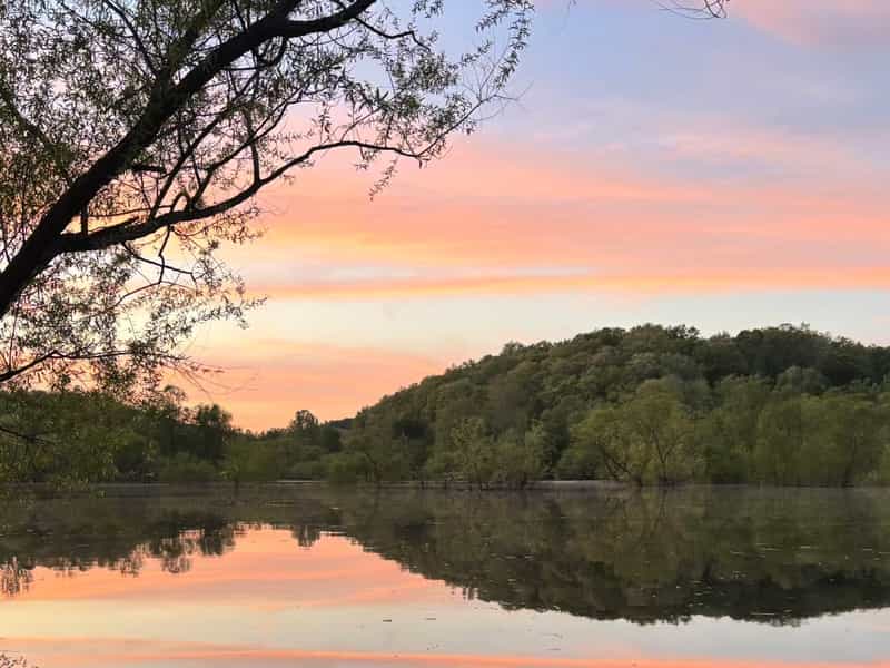 Sunset over wooded hills reflected in Monroe Lake near Bloomington