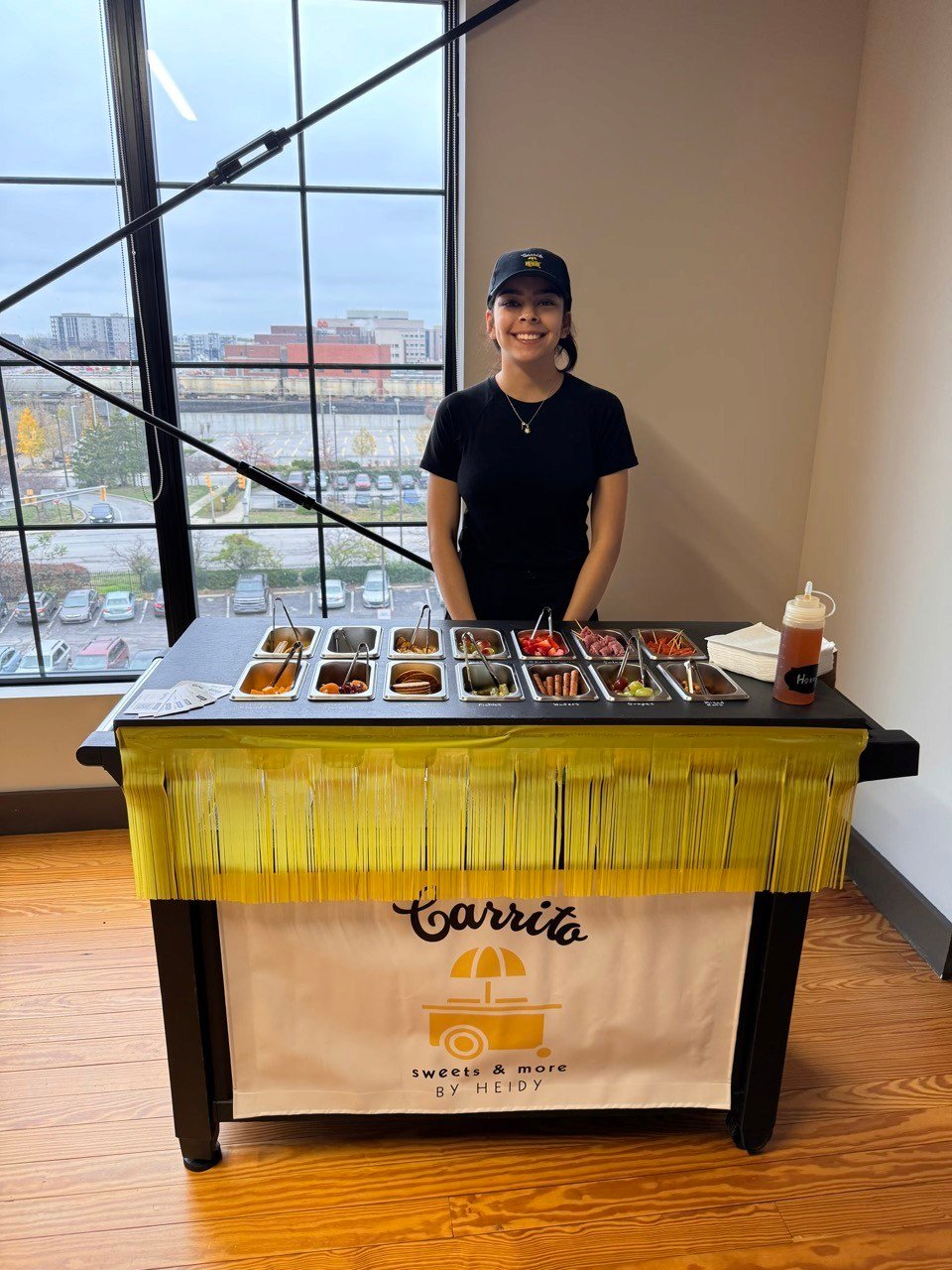 A student standing behind her Carrito Sweets and More dessert cart.