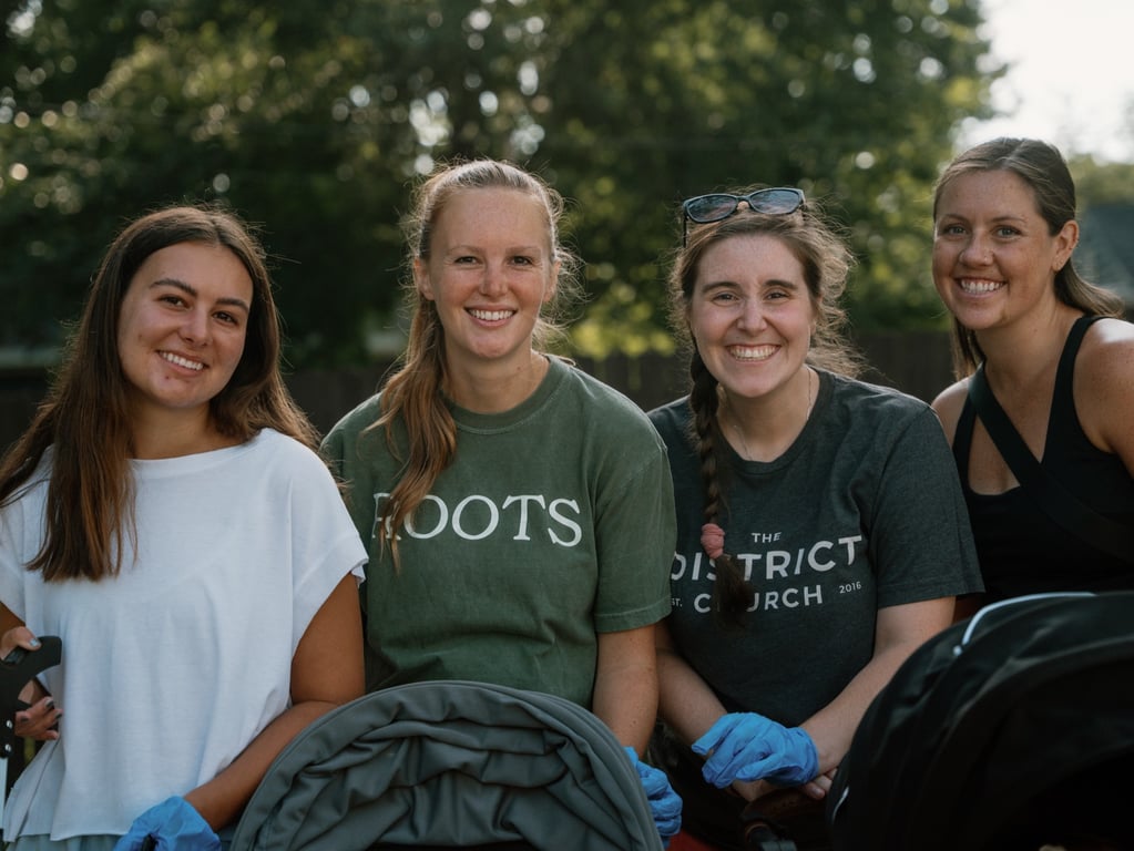 Four volunteers, including Roots and District Church tees, at the sweep