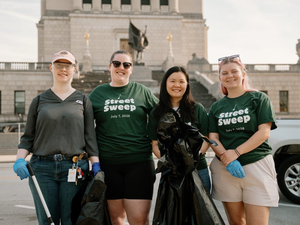 Volunteers with trash bags in front of the Indiana World War Memorial