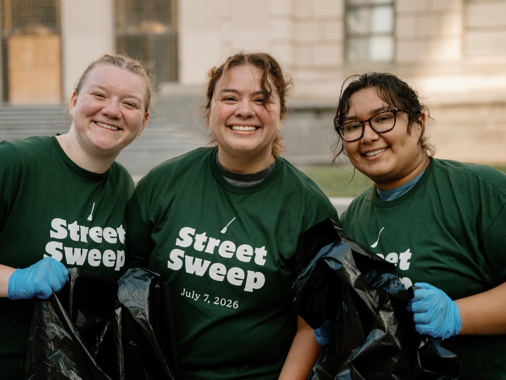 Three volunteers smiling together during the sweep