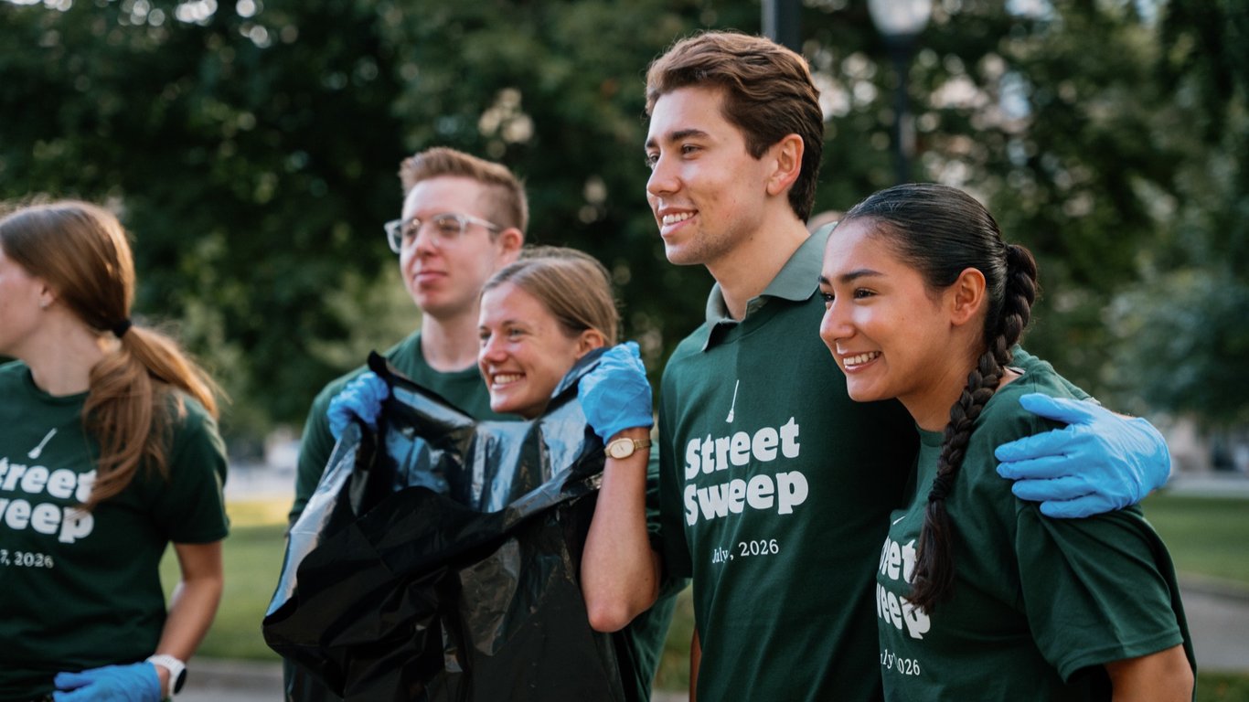 A crew of young volunteers heading out together with a trash bag