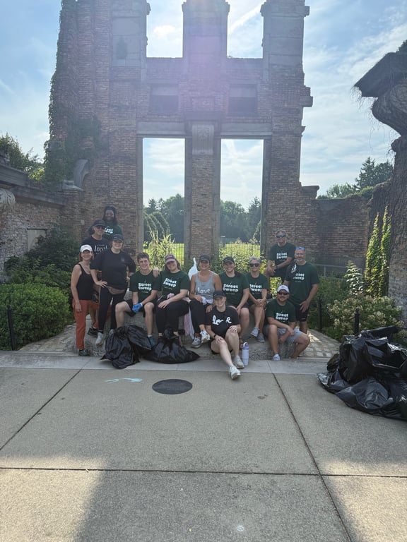 Sweep volunteers gathered by the historic stone columns downtown