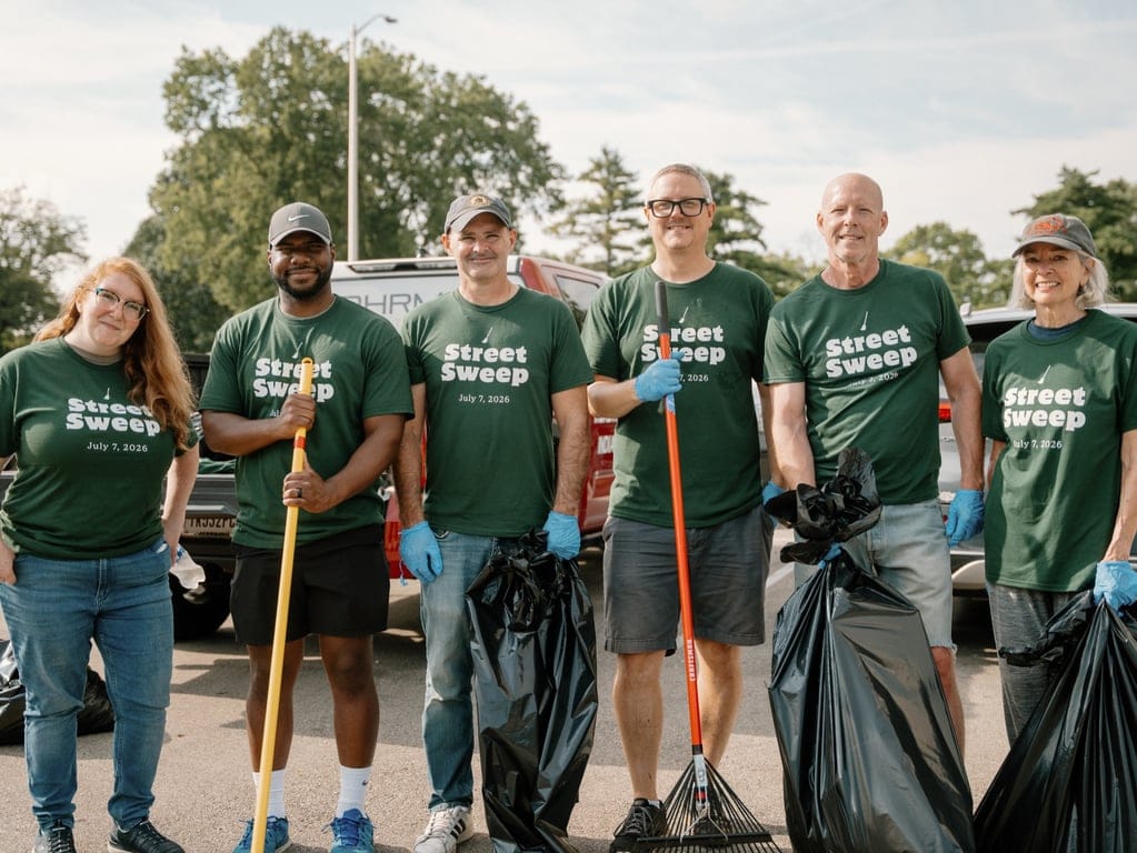 Indy Street Sweep volunteers holding rakes and trash bags