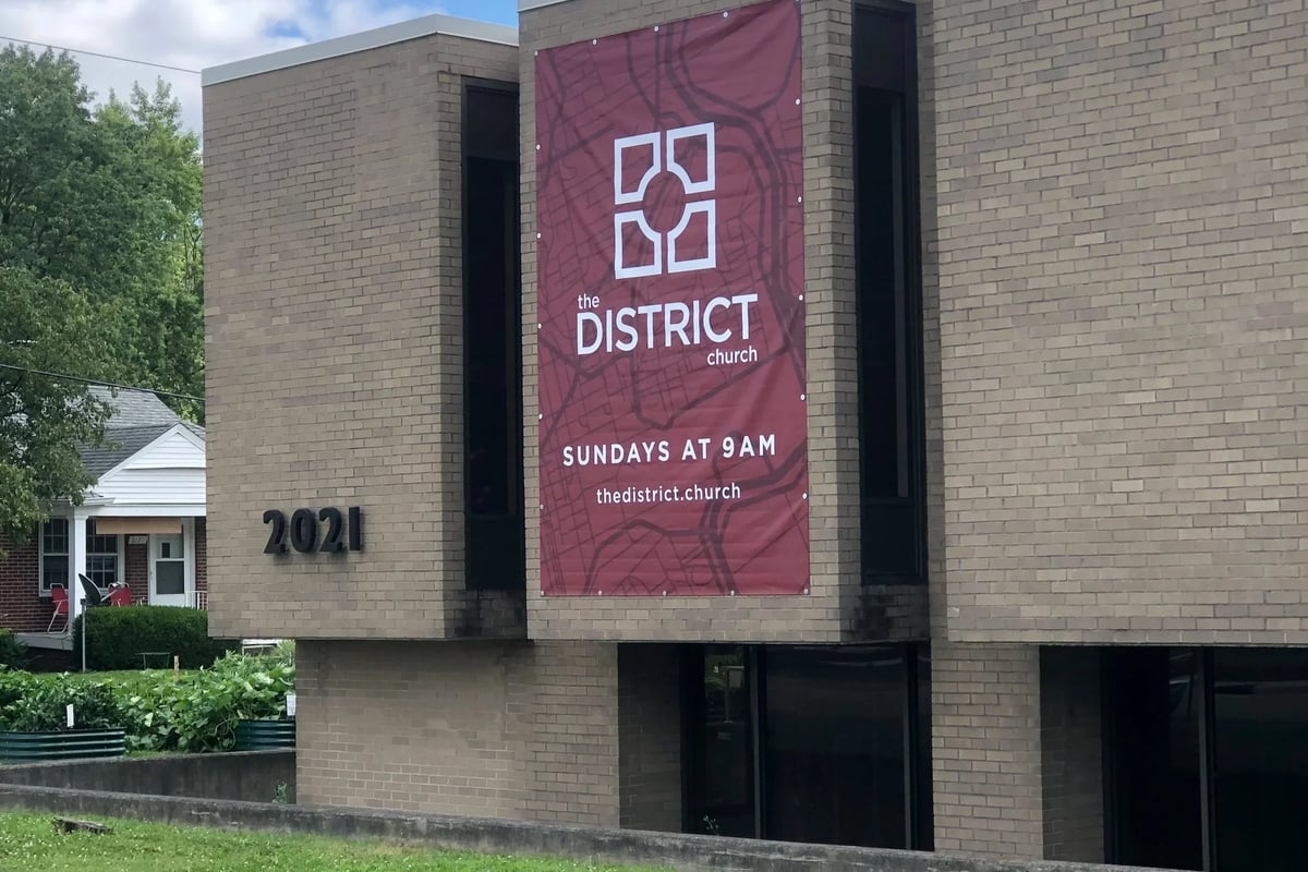 The District Church building at 2021 E 52nd St in South Broad Ripple, with the church's banner reading Sundays at 9AM