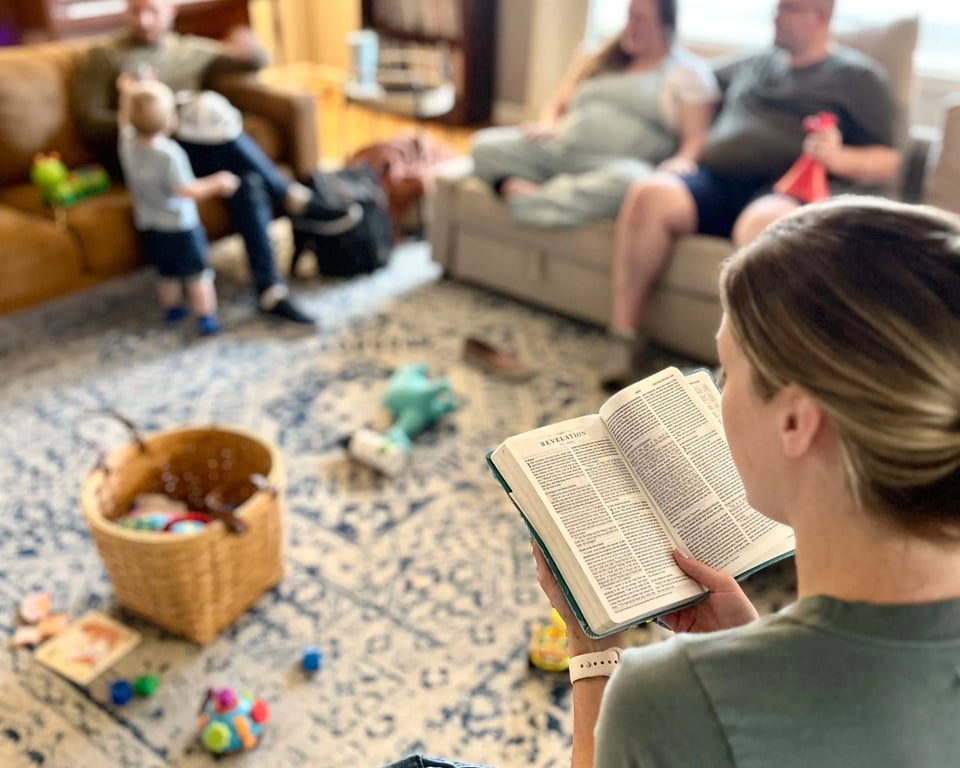 A woman reading her Bible during a District Church Community Group, with families and children around the living room