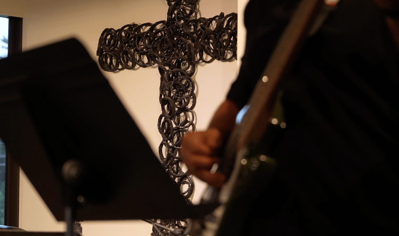 The iron cross on the wall behind the worship team