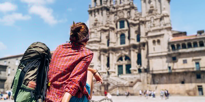 a female backpacker admiring the Cathedral of Santiago de Compostela in Spain