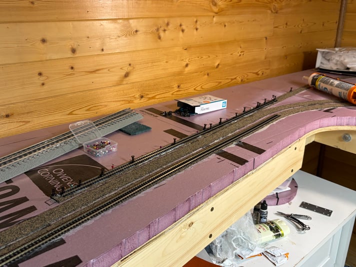 The first section of flex track being glued down, Day 13 of track work