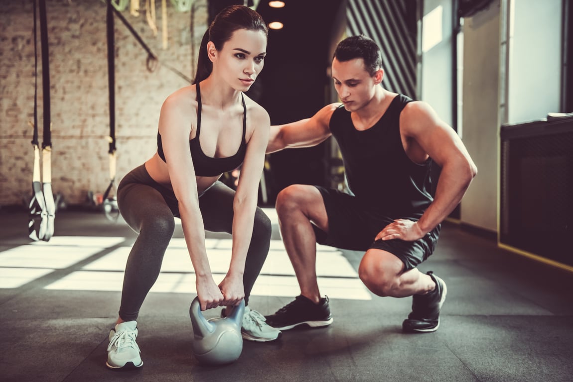 Guy helping girl workout