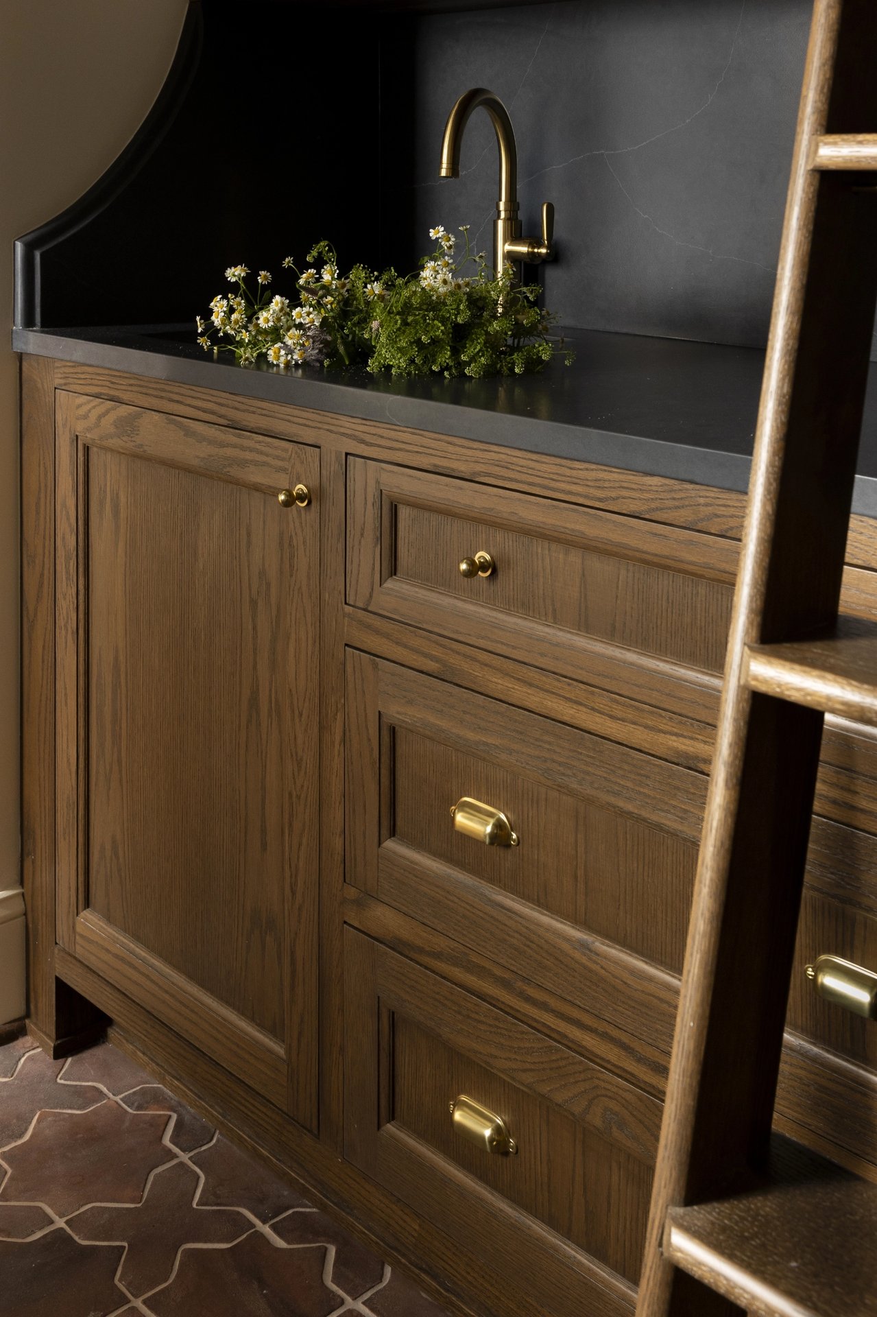 Floor-to-ceiling pantry cabinet with minibar and library ladder