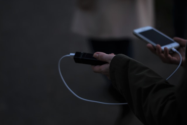 Powerbank ładujący smartfon w plecaku podczas letniej wycieczki
