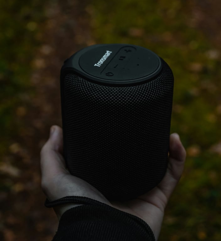 Przenośny głośnik Bluetooth grający przy basenie w słoneczny dzień