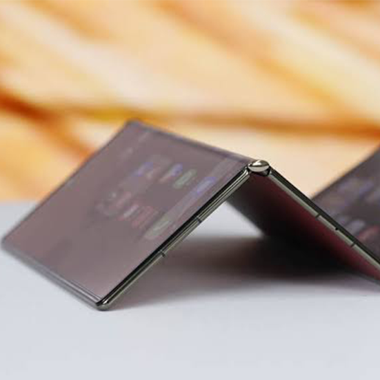 Składany smartfon z otwartym elastycznym ekranem leżący na biurku
