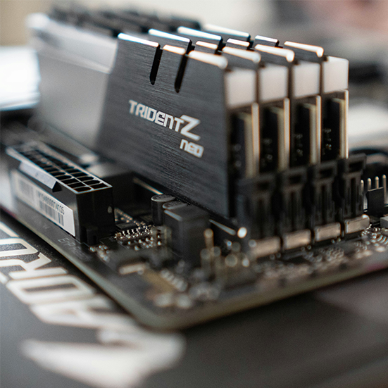 Moduły pamięci RAM DDR5 i dysk SSD M.2 leżące na płycie głównej komputera
