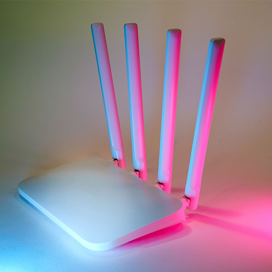 Jednostka systemu mesh Wi-Fi stojąca na półce w salonie