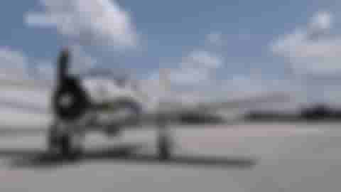 A gif of a prop plane sitting on a runway with its propellor spinning quickly