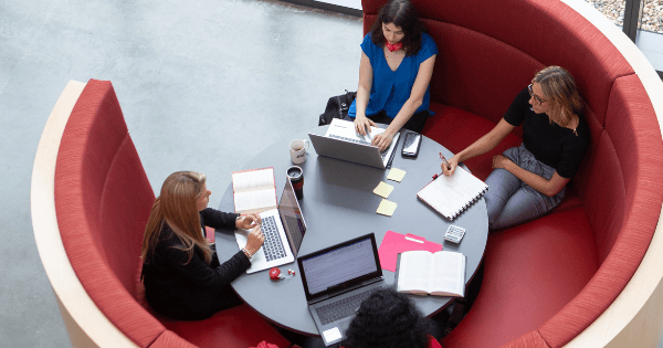 Business professionals collaborating with laptops and notes at a table