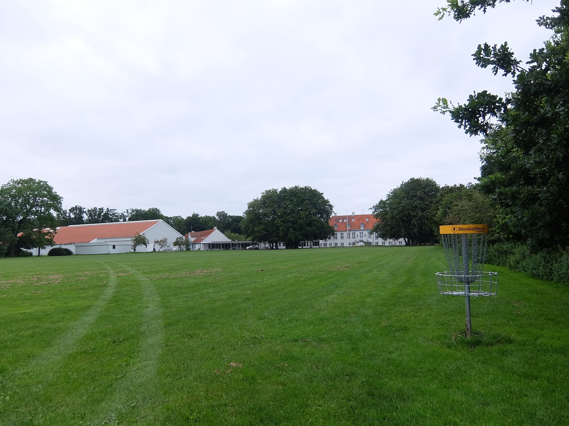 Standing at tee 2 you can see the entire school and the first basket, which is also the last goal (the other photo show the direction you throw, this is just the view:)