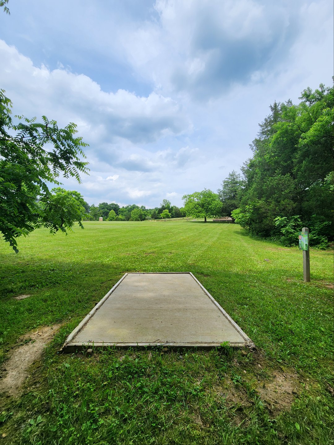 Tee pad
Basket location is straight ahead, slight right, across road and up on hill
OB - gravel area