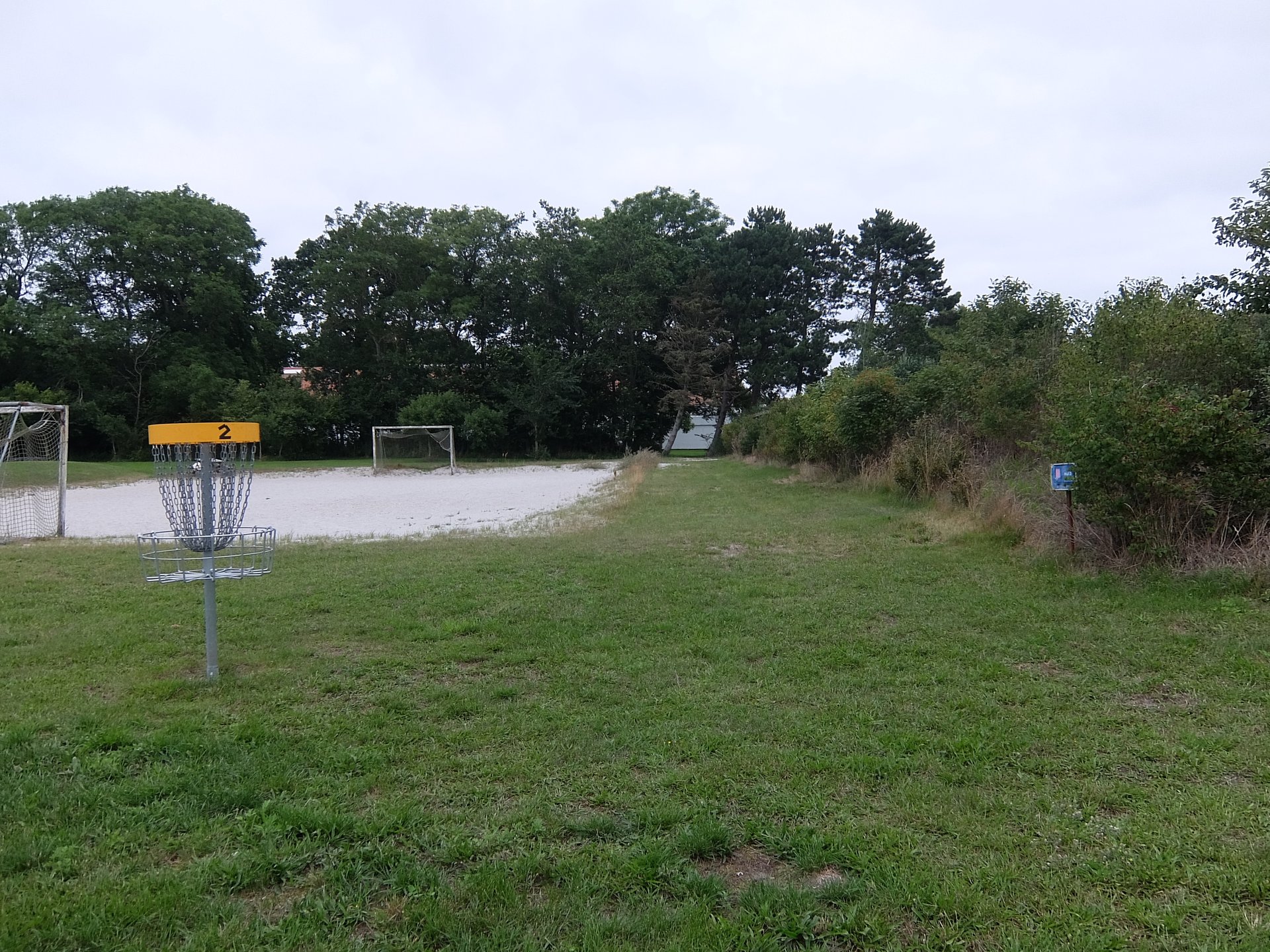 Tee 3 is behind the second basket by the volleyball OB sand, this has a gap straight ahead, avoiding hitting the shed to the right!!
