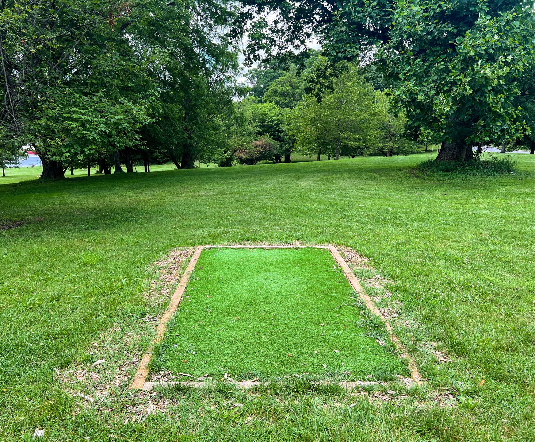 Hole 8's tee. Par 4. Pink is down the hill and back up to the right. Yellow is past the Pink basket slight to it's left, but back down the other side of the hill. Pink is 470 ft., Yellow is 601 ft. Road on the right is OB. 