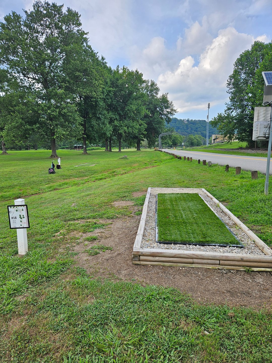 Long Tee Pad. OB Beyond Road. Mando Right of Tree with Sign.