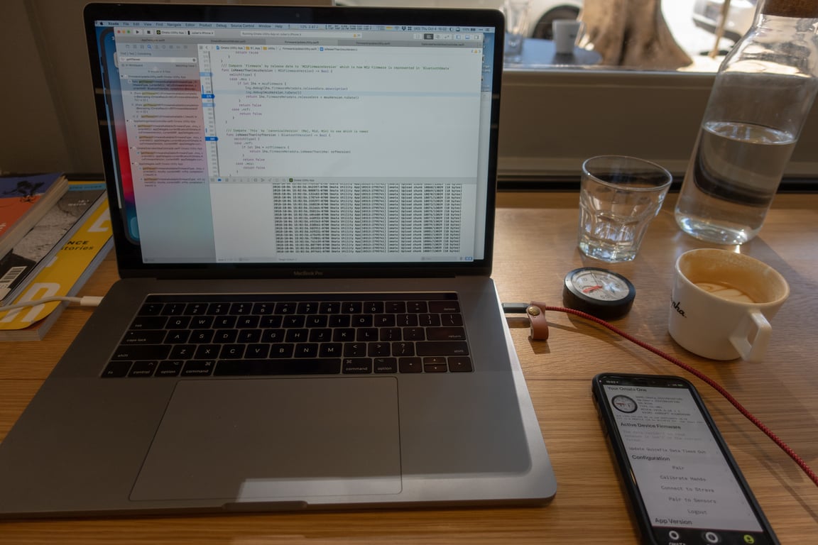 Xcode, a phone, an OMATA One and coffee sharing a table.
